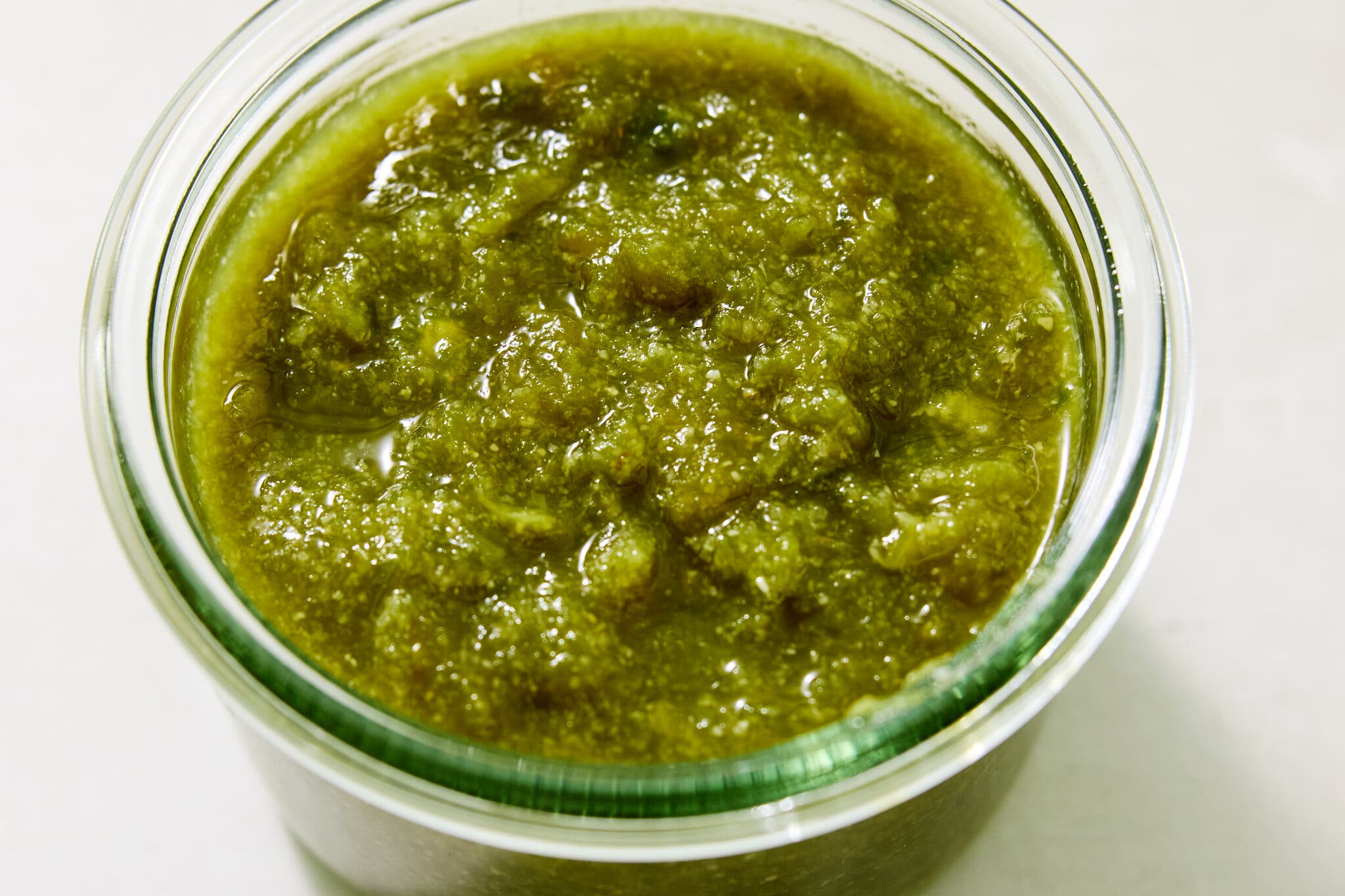 A deep yellow-green salsa sits in a clear jar.