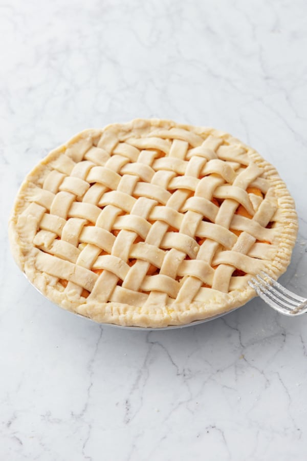 Crimping edges of crust with a fork to form a seal.