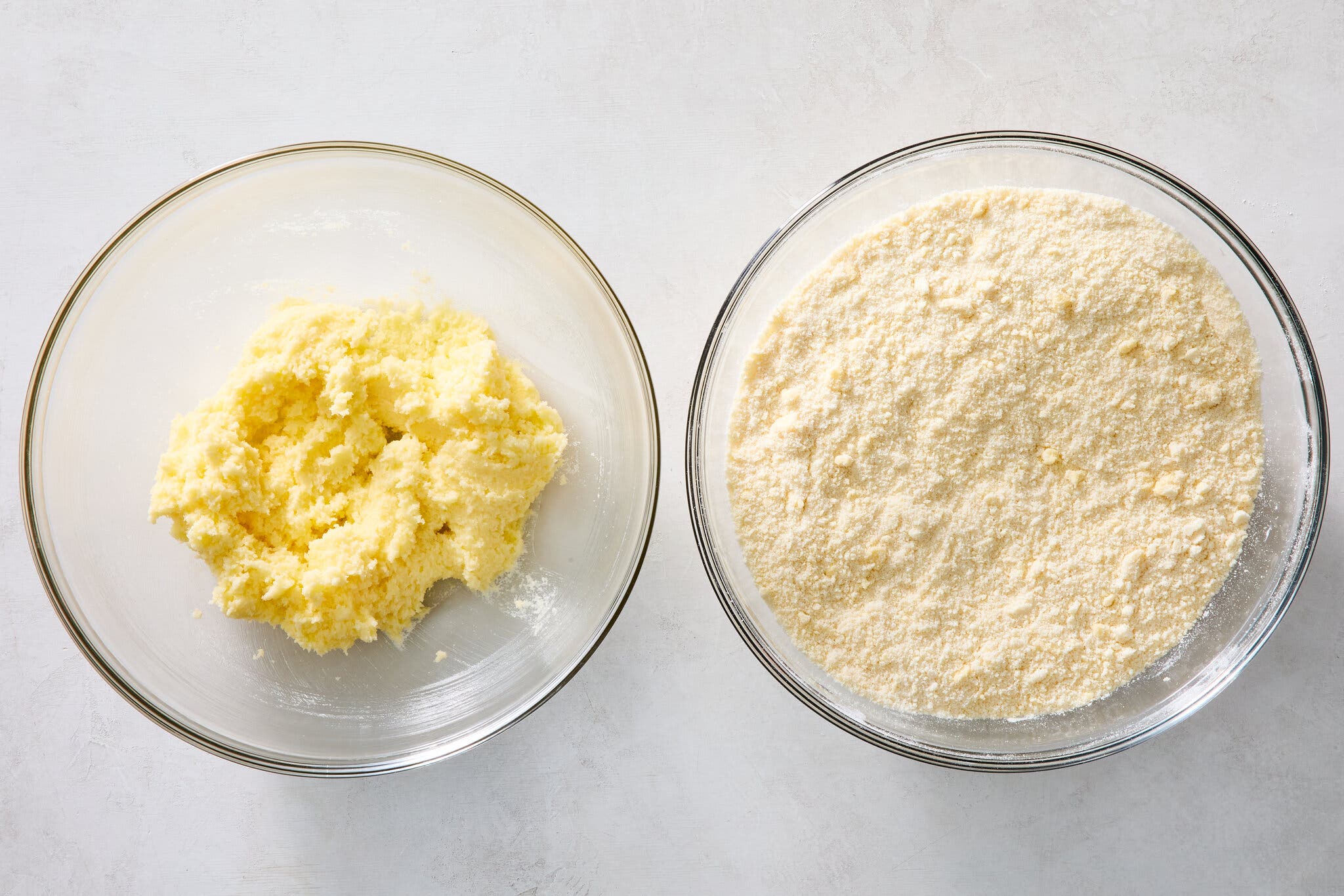 An overhead image of two clear bowls: One filled with mixed butter and the other with sugar.
