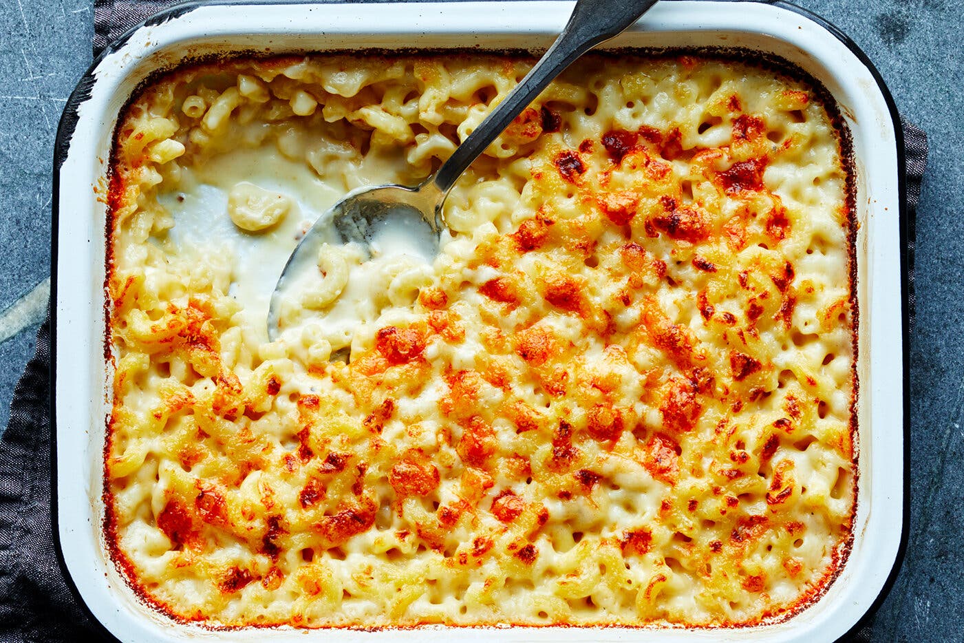 An overhead image of a baking dish filled with macaroni and cheese. A scoop has been pulled out from one side.