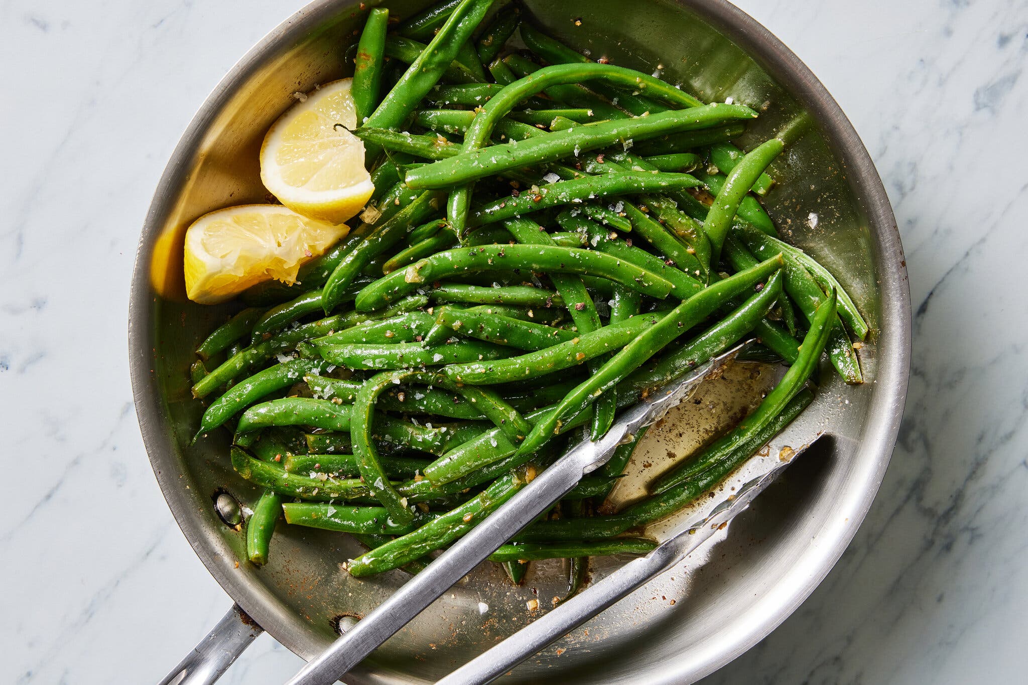 An overhead image of a skillet filled with green beans.