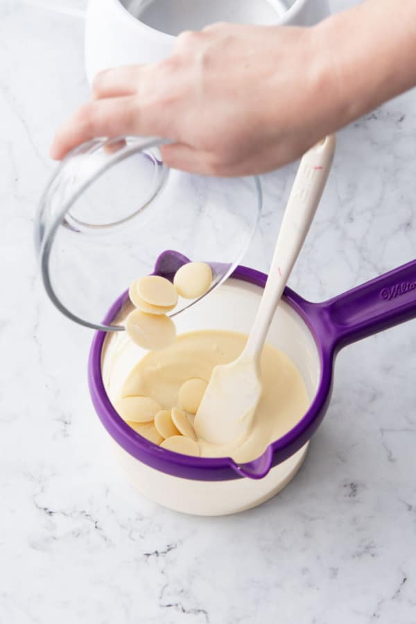 Adding remaining seed chocolate to the melted white chocolate.
