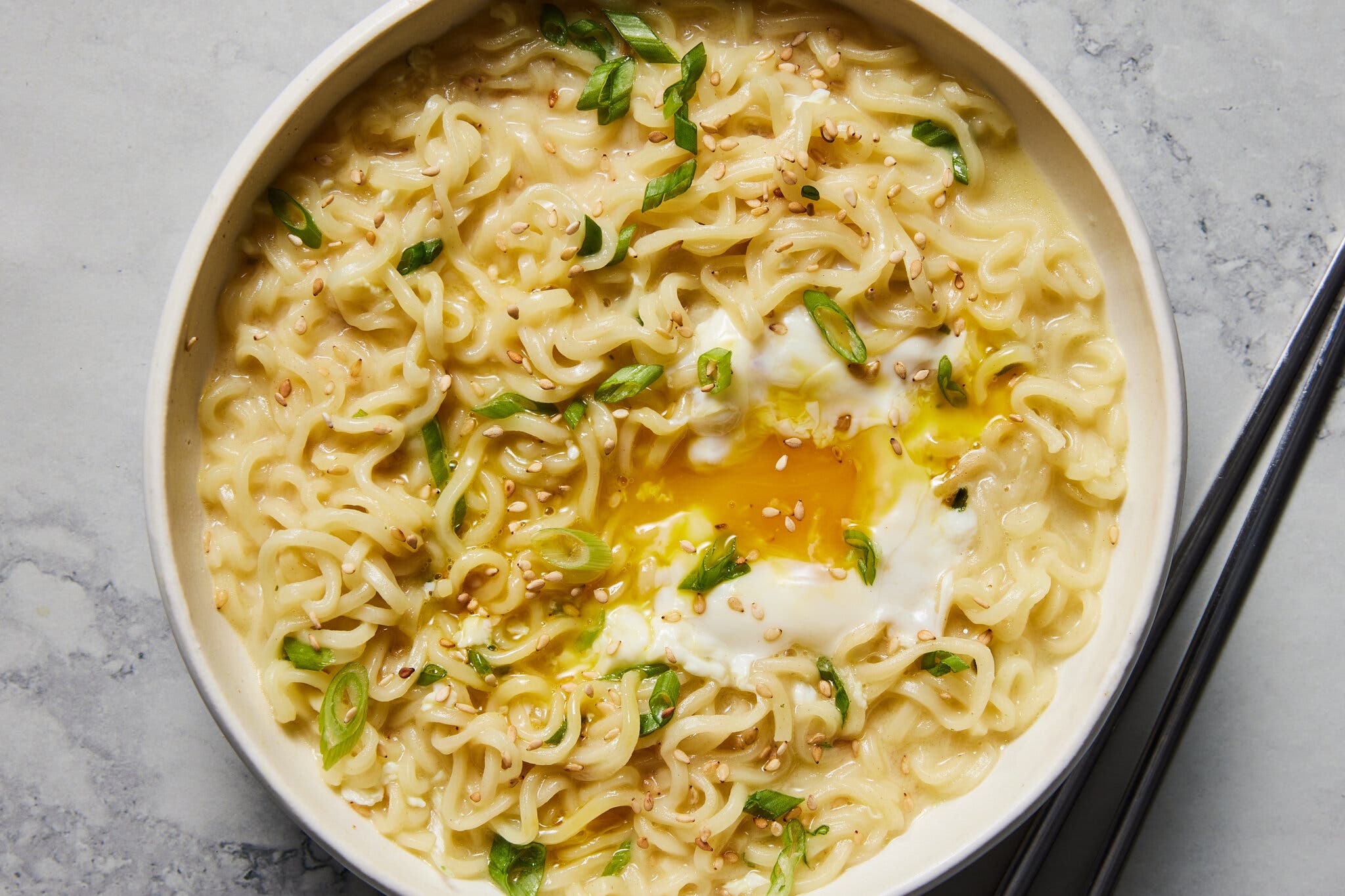 An overhead image of a bowl of ramen with a runny egg in the middle.